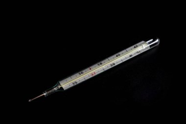 Siyah bir arka plan üzerinde vücut sıcaklığı ölçme termometresi