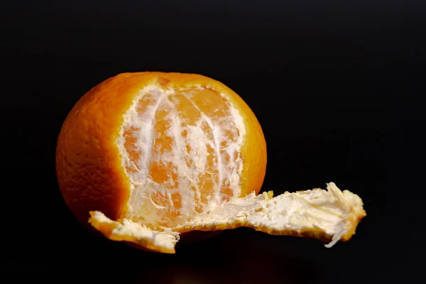 Bir arka plan siyah yakın çekim 2018 üzerinde yarısı soyulmuş mandarin