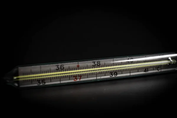 用于测量黑色背景上的体温的温度计 — 图库照片