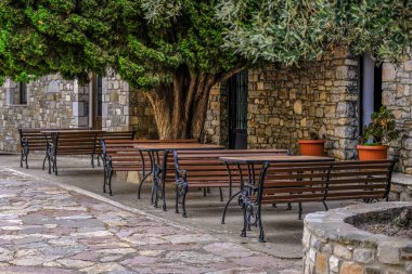 Tablolar ve banklar asırlık ağacın altında. Cafe 2018