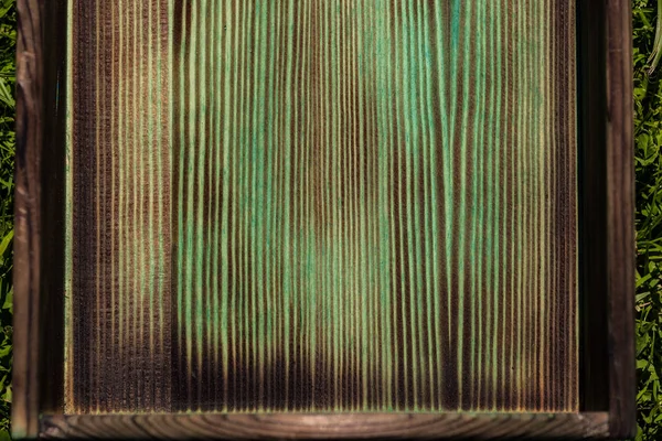 Burnt bottom of a wooden green box close up 2018
