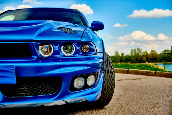 Агрессивный спортивный автомобиль в синем на фоне природы — стоковое фото