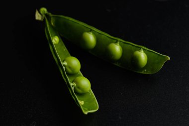 Siyah bir arka plan üzerinde su damlaları taze bezelye yakın çekim