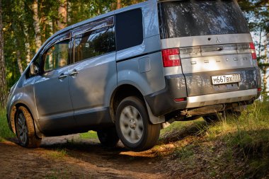 Akşamları sonbahar ormanında off-road minivan