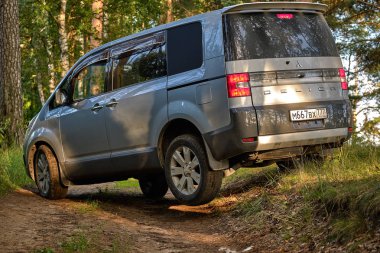 Akşamları sonbahar ormanında off-road minivan