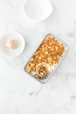 Ev yapımı Toffee elma dondurma vanilyalı dondurma, elma, şekerleme sos ve metal konteyner ve kase tarçın çatlar.