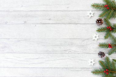 Doğal köknar ağacı twigs, Beyaz ahşap Noel yıldız, karlı çam kozalakları ve beyaz ahşap paneller üzerine kırmızı meyveler ile Noel arka plan. Üstten görünüm.        