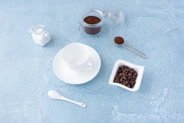 Boş kahve fincanı, beyaz şeker ve cam kavanoz mavi beton zemin üzerine çekilmiş kahve kahve kavramı.