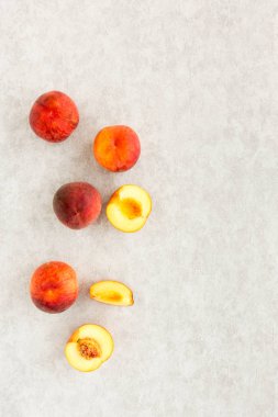 Amber Blush şeftali, bütün ve kesim yarısı ve dilimleri gri arka plan ile lots-in kopya alanı desenli. Üstten görünüm.