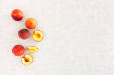 Amber Blush şeftali, bütün ve kesim yarısı ve dilimleri gri arka plan ile lots-in kopya alanı desenli. Üstten görünüm.