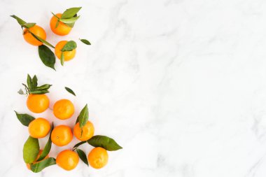 Düz Clementines yaprakları ile lots-in kopya alanı beyaz mermer zemin üzerine yatırın. Üstten görünüm.