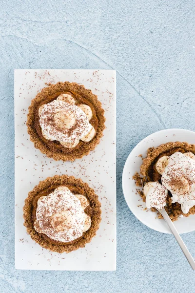 Vue du dessus des tartes Banoffee maison sur le béton bleu — Photo