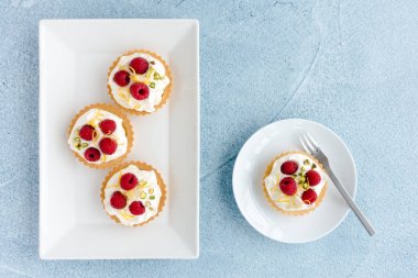 Plakalar ve Mavi Beton Arka Plan üzerinde Ahududu Tartlets