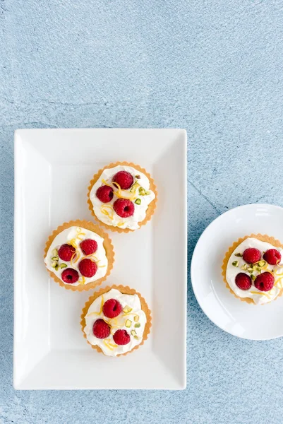 Tartelettes à la framboise maison décorées avec des noix de pistache et du zeste de citron — Photo