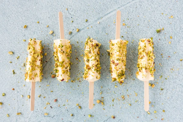 Mango en pistache Kulfi lollies op blauwe cement achtergrond — Stockfoto