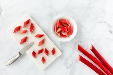 Closeup of Cut Rhubarb and Rhubarb Stalks on White Marble Background clipart