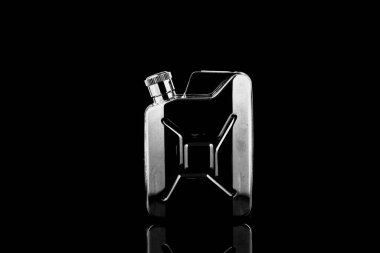 Siyah arka planda metal bir cep şişesi. Alkol şişeleri.