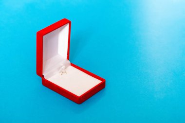 Mavi arkaplanda kırmızı kadife kutuyu aç