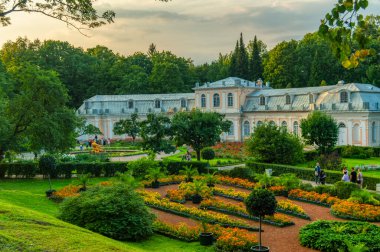 Büyük Peterhof Sarayı 'nda gün batımında büyük portakalcılık. Peterhof Lower Park 'ta yazın büyük bir sera. Saint Petersburg, Rusya, Ağustos 2018
