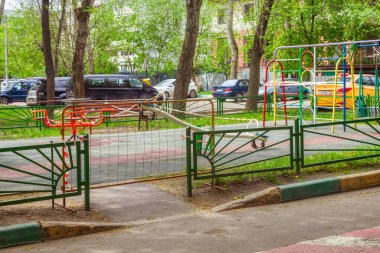 Oyun parkının girişi metal bir şebeke tarafından kapatılmış. Oyun alanı, karantina sırasında kullanılmasını yasaklayan kırmızı-beyaz sinyal bandıyla bağlı. Moskova, Rusya-Nisan 2020