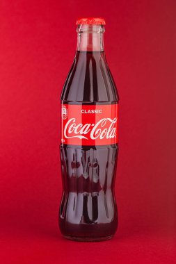 Kırmızı zemin üzerinde 0.33 litre izole edilmiş klasik Coca-Cola şişesi. Moskova, Ağustos, 2020
