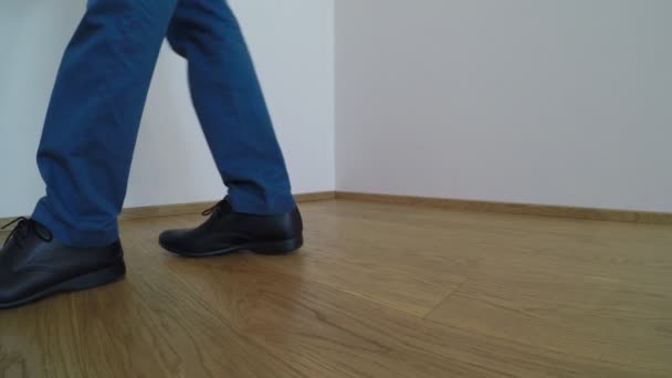 男子穿着蓝色的鞋子和裤子 洗镶木地板与黄色拖把 — 图库视频影像