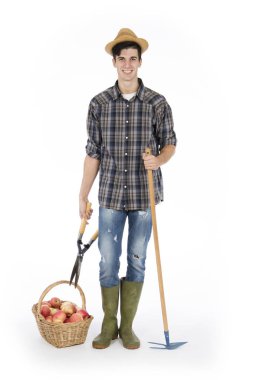 Makası ve Komisyon, ayaklarına sepet kırmızı elma, dolu bir genç çiftçi bir hasır şapka, ekose desenli gömlek ve yeşil lastik çizme giyiyor