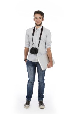 İnek çocuk ile kamera onun boyun ve bilgisayar kolunun altında o stüdyoda ayakta ve rahat kıyafetler giyiyor