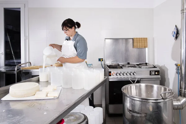 Cheesemaker a aludttejet a műanyagformába vezeti — Stock Fotó