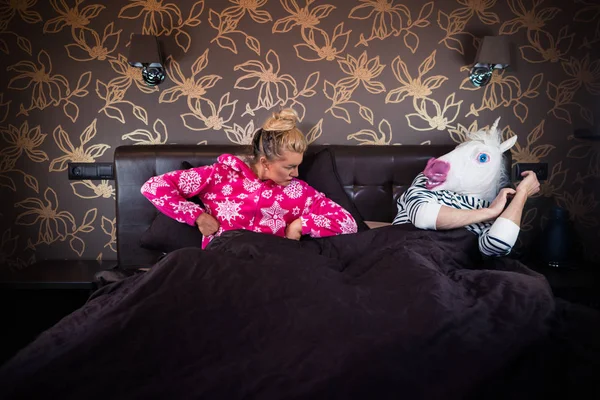 Jonge vrouw in pyjama liggend op bed met vriendje Rechtenvrije Stockfoto's