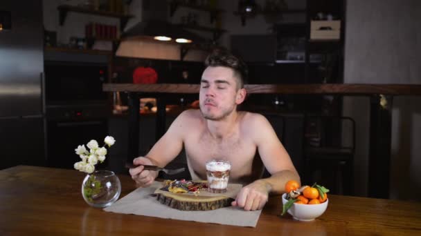 Ung Man Sitter Vid Bordet Och Äter Pannkakor Frukost Morgonen — Stockvideo