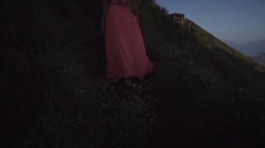 Pembe elbiseli çıplak ayaklı genç kadın üzerinde geri görünümü yürüyüş ve vadi, gökyüzü, maymunlar ve dağların arka planda volkanın üstüne siyah iz üzerinde yükselen. 