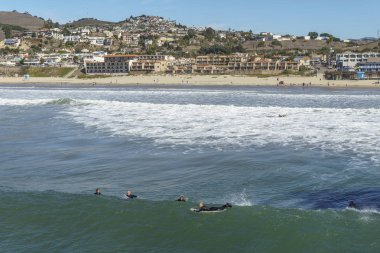 Pismo beach içinde belgili tanımlık geçmiş ile okyanusta yüzmeye sörfçü