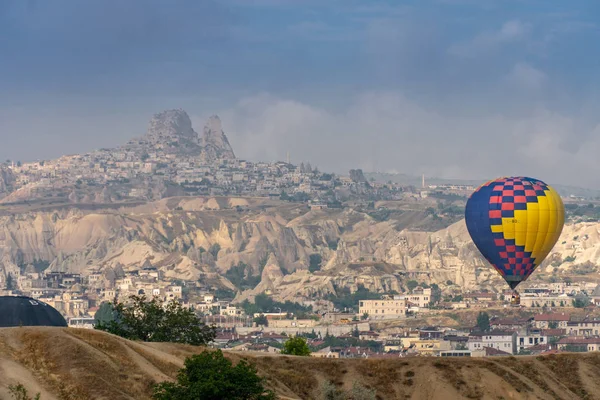 Globos aterrizando en Rose Valley, Capadocia con Uchisar en el —  Fotos de Stock