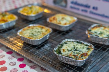 Fırında lazanyayı sokak pazarında metal bir tabakta yakın çekim yap.