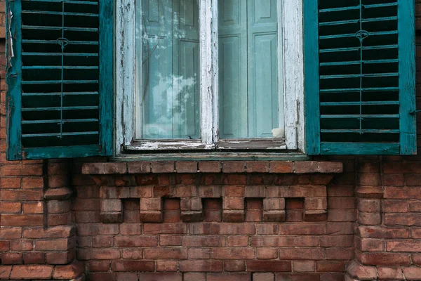 Old green window with open shutters. Brick wall. Background, texture