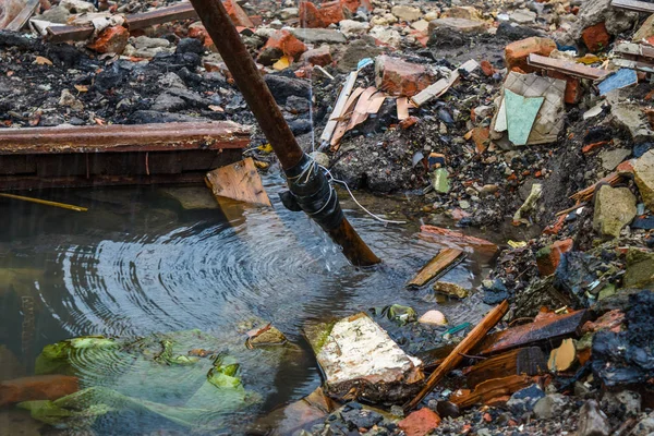 Water jet from the burst pipe. A pool about a water supply system