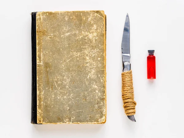 Book, knife and ampoule with blood on a white background. Set for magic.