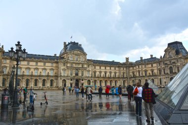 Paris, Fransa - 25 Mayıs 2019: Ünlü Paris Louvre. Ana avludaki insanlar (Cour Napolyon) 