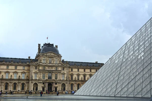 Paris, Fransa - 25 Mayıs 2019: Ünlü Paris Louvre. Louvre Piramit ile Louvre Müzesi ile ana avlu (Cour Napolyon) İnsanlar
