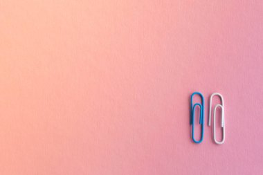 Açık mor arka planda çok renkli ataçlar, okul veya iş için kırtasiye malzemesi