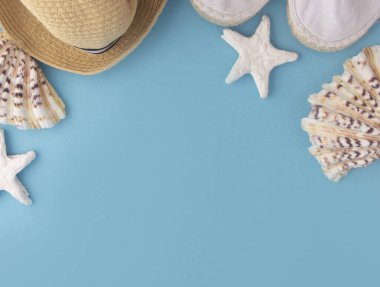 Yaz tatili ve plaj tatili. Hasır şapka, mavi arka planda denizyıldızı. Seyahat kavramı