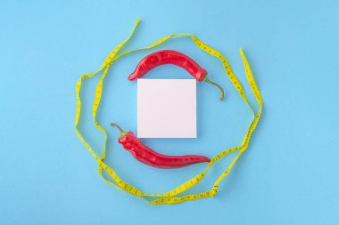 kırmızı biber, beyaz boş ve mavi arka planda mezura.