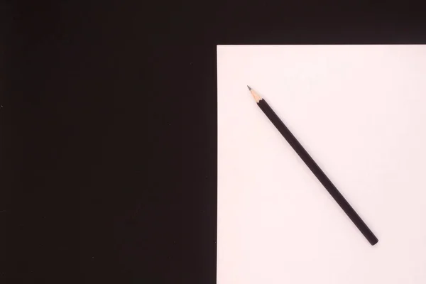 Auf Einem Schwarzen Tisch Liegen Schwarze Bleistifte Und Weißes Papier — Stockfoto