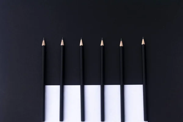 Egy Fekete Asztalon Fekszenek Fekete Ceruzák Fehér Papír Munkahelyi Lapos — Stock Fotó