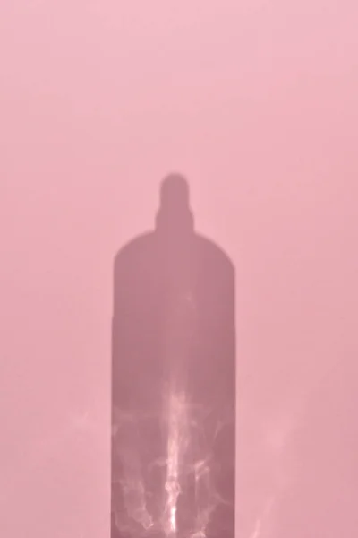 粉色背景上的瓶装水的阴影 美的概念 — 图库照片