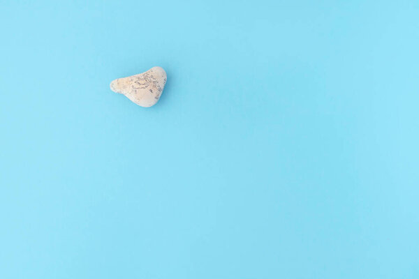 sea stone in the form of a heart on a blue background. Vacation concept