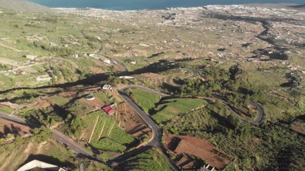 Tiro aéreo. Voo sobre uma nova estrada de montanha sinuosa asfalto ao longo do qual vários carros estão se movendo. Novas marcas na estrada. pino de cabelo virar. Em primeiro plano são árvores e espaço verde, no fundo há — Vídeo de Stock