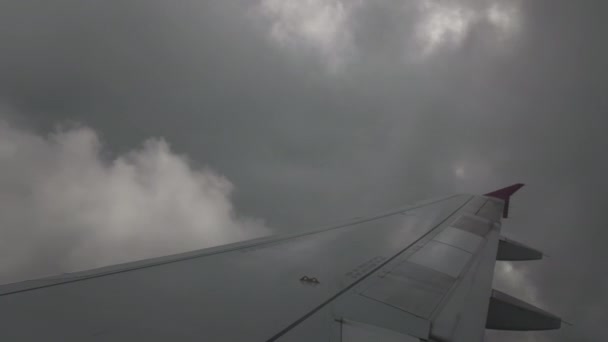 Turbulência severa ao voar através de nuvens de trovoada. A asa está muito solta. Contra o fundo de nuvens cinzentas texturizadas e volumétricas. O conceito de medo de voar em um avião, o — Vídeo de Stock
