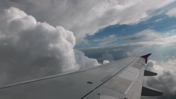 Letu letadla za texturou a objemové šedé mraky a modrá obloha. první osoba pohled z kokpitu letadla, v rámci šedá křídla s růžovou wingtip zařízení — Stock video